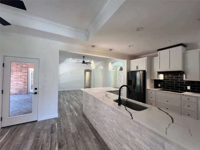 a kitchen with granite countertop a refrigerator stove and sink