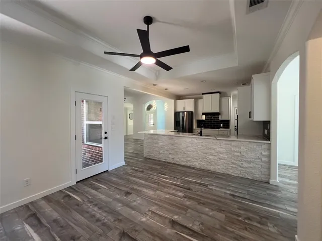 a view of empty room with wooden floor