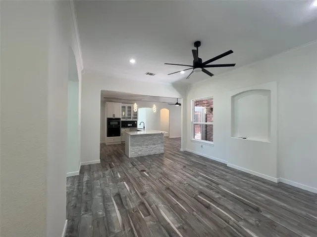 a view of a living room hardwood floor and a ceiling fan