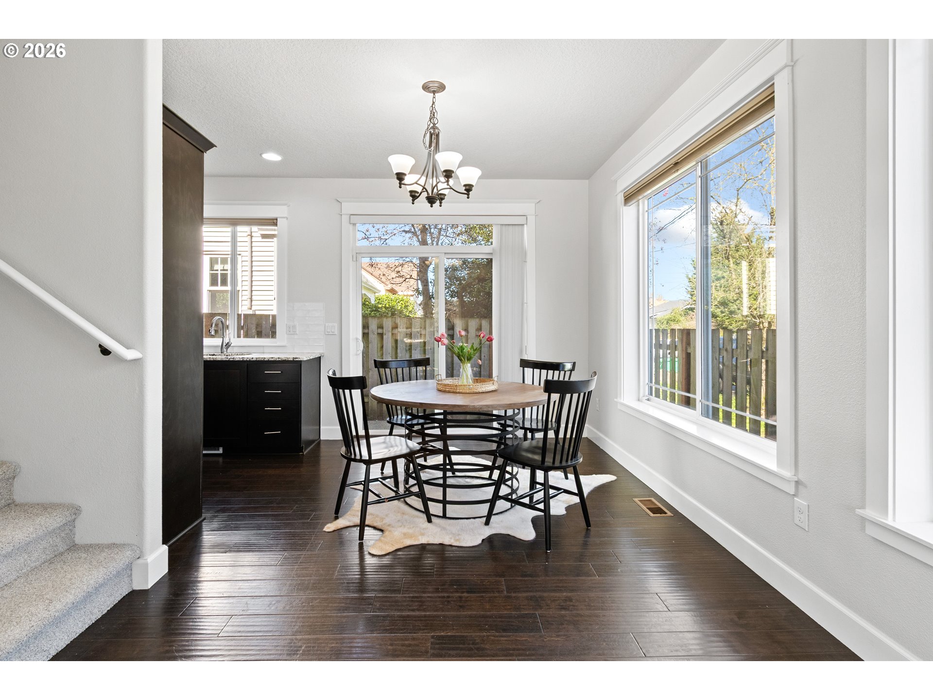 7473 Northeast Fremont Street Portland, OR 97213 - Photo 11 of 41 a dining room with wooden floor a chandelier a wooden table and chairs