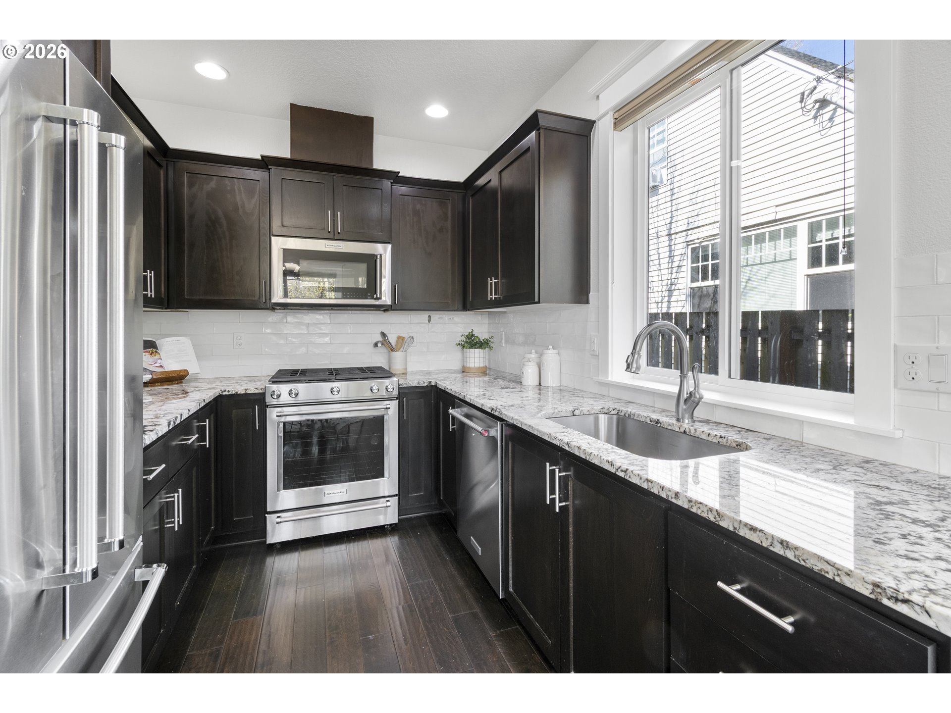 7473 Northeast Fremont Street Portland, OR 97213 - Photo 14 of 41 a kitchen with stainless steel appliances kitchen island granite countertop a sink stove and refrigerator