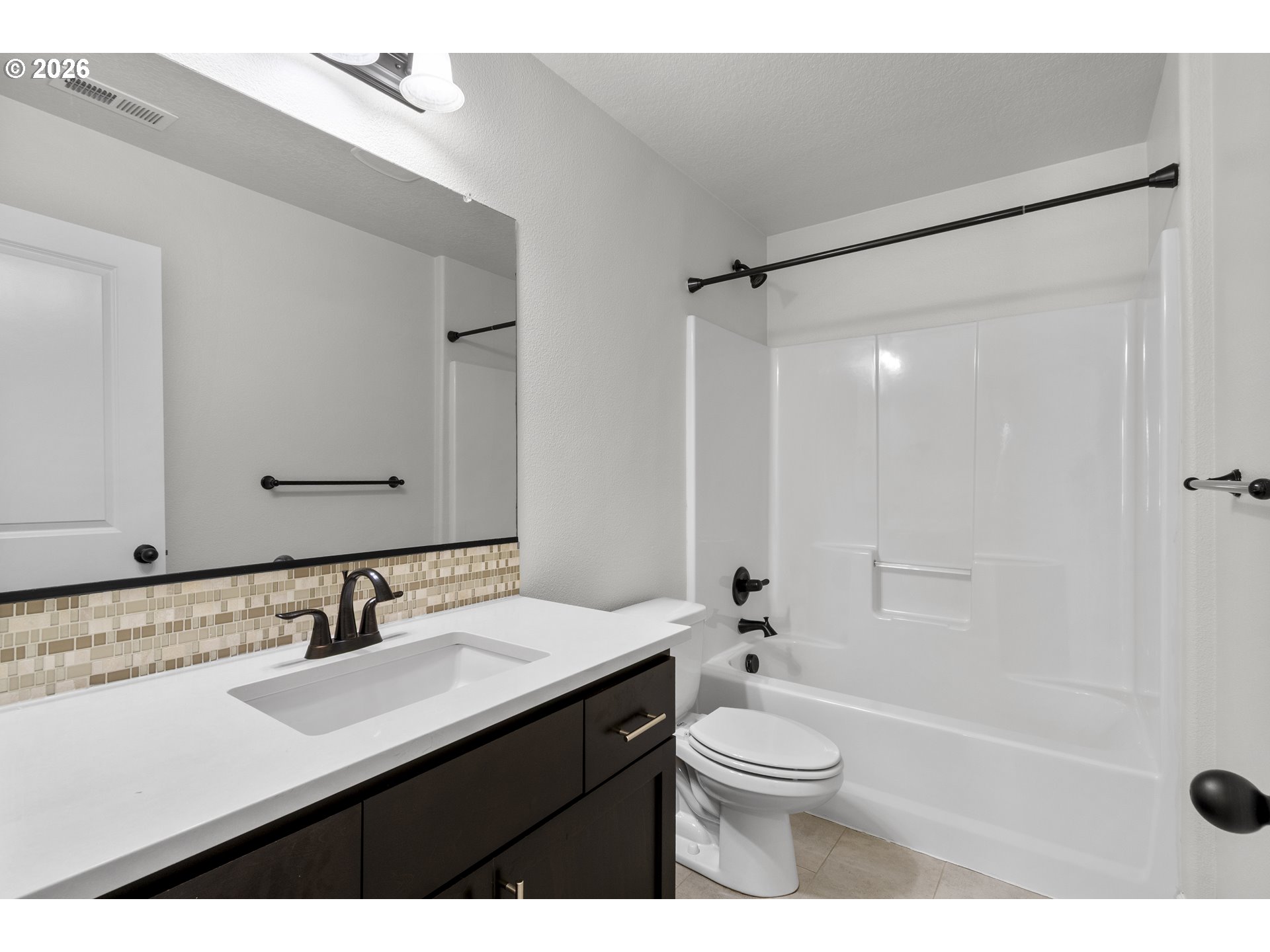 7473 Northeast Fremont Street Portland, OR 97213 - Photo 26 of 41 a bathroom with a sink a toilet a mirror a bathtub and shower