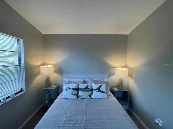 a bed room with a lamp and a lamp on table