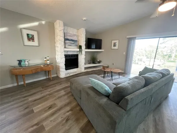 a living room with furniture a fireplace and a large window