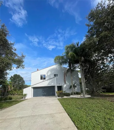 a view of a big house with a big yard and large trees