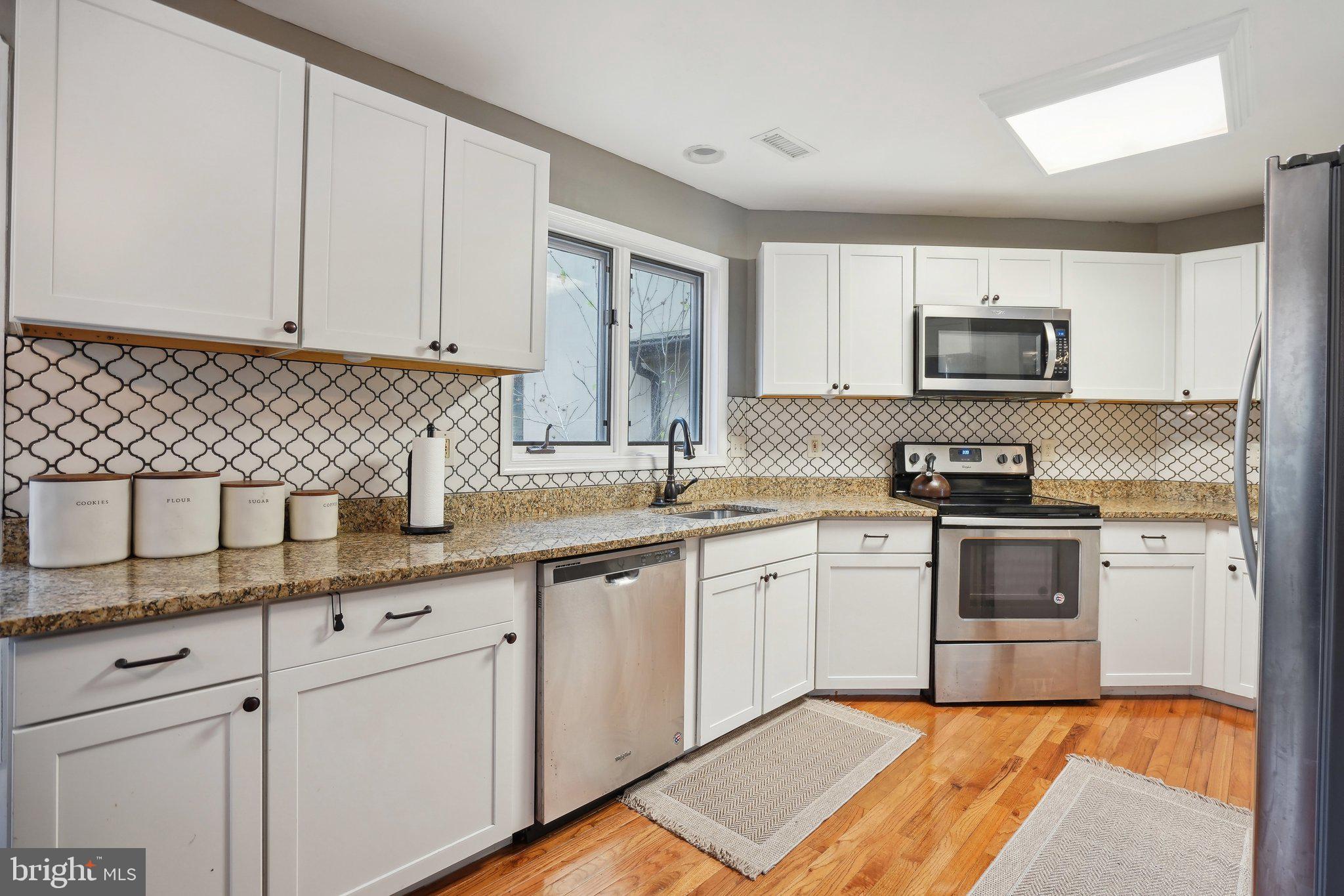 3111 Courtside Road Bowie, MD 20721 - Photo 17 of 41 a kitchen with granite countertop white cabinets and black appliances