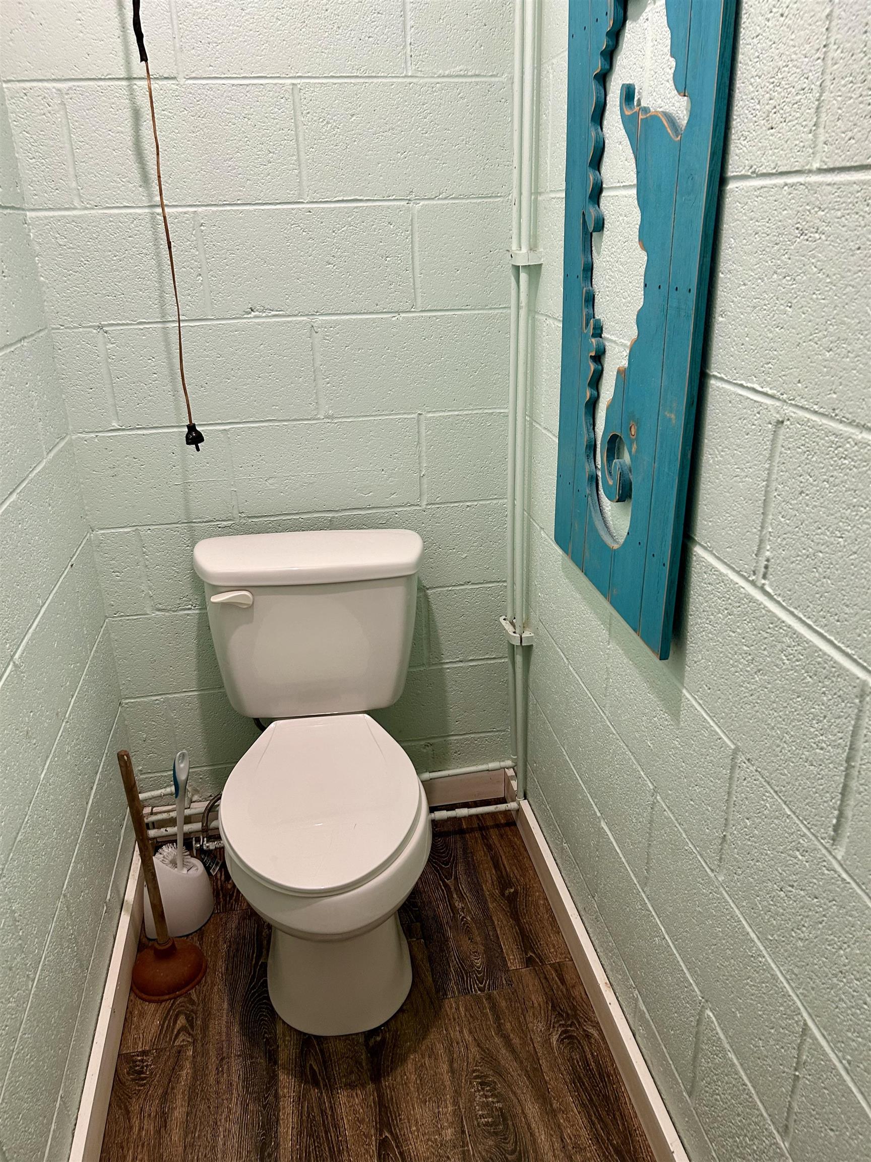 460 Port Lane Counce, TN 38326 - Photo 19 of 23 Bathroom with concrete block wall and dark wood-type flooring