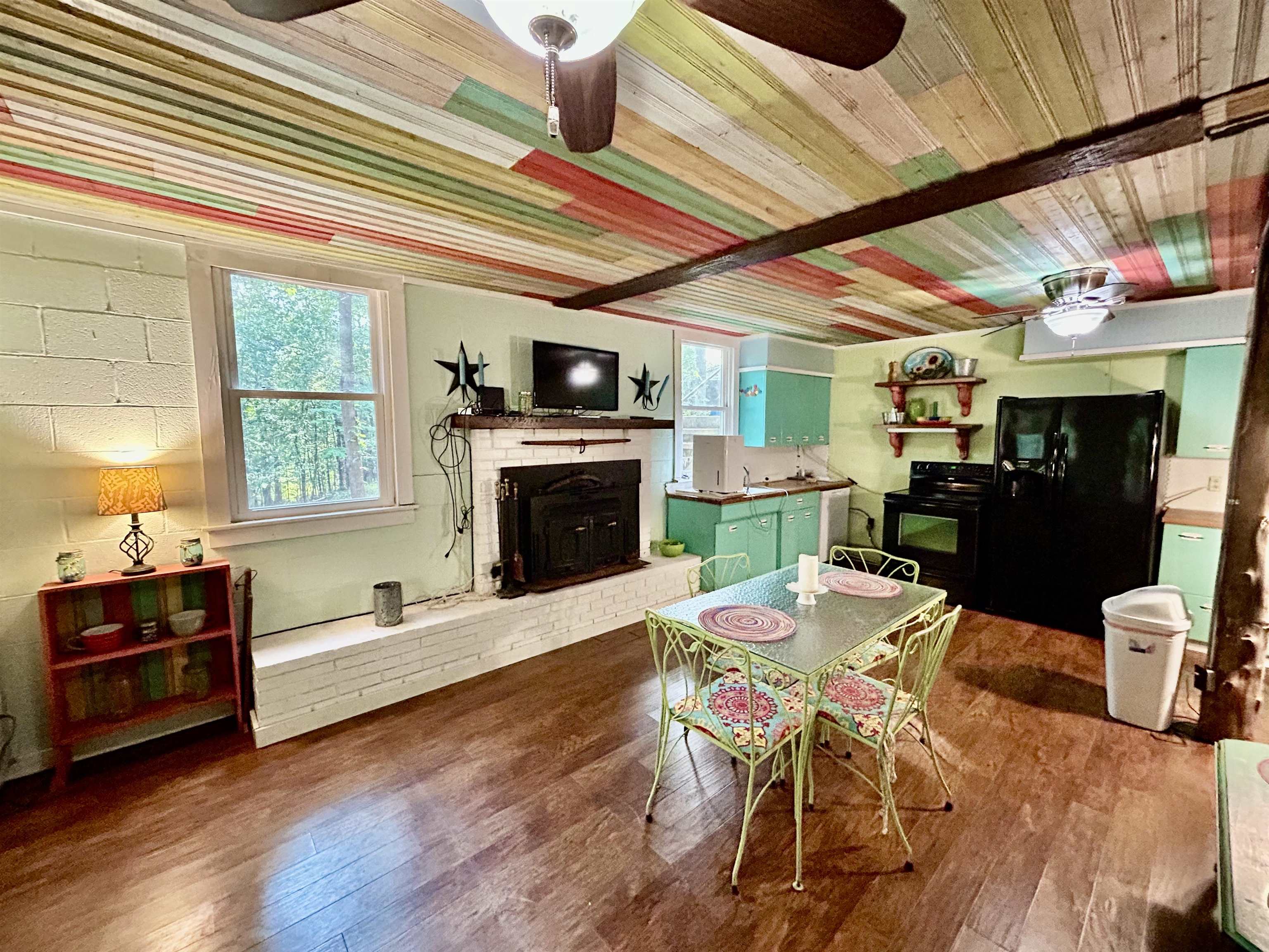 460 Port Lane Counce, TN 38326 - Photo 4 of 23 Dining space featuring ceiling fan, hardwood / wood-style floors, and a fireplace