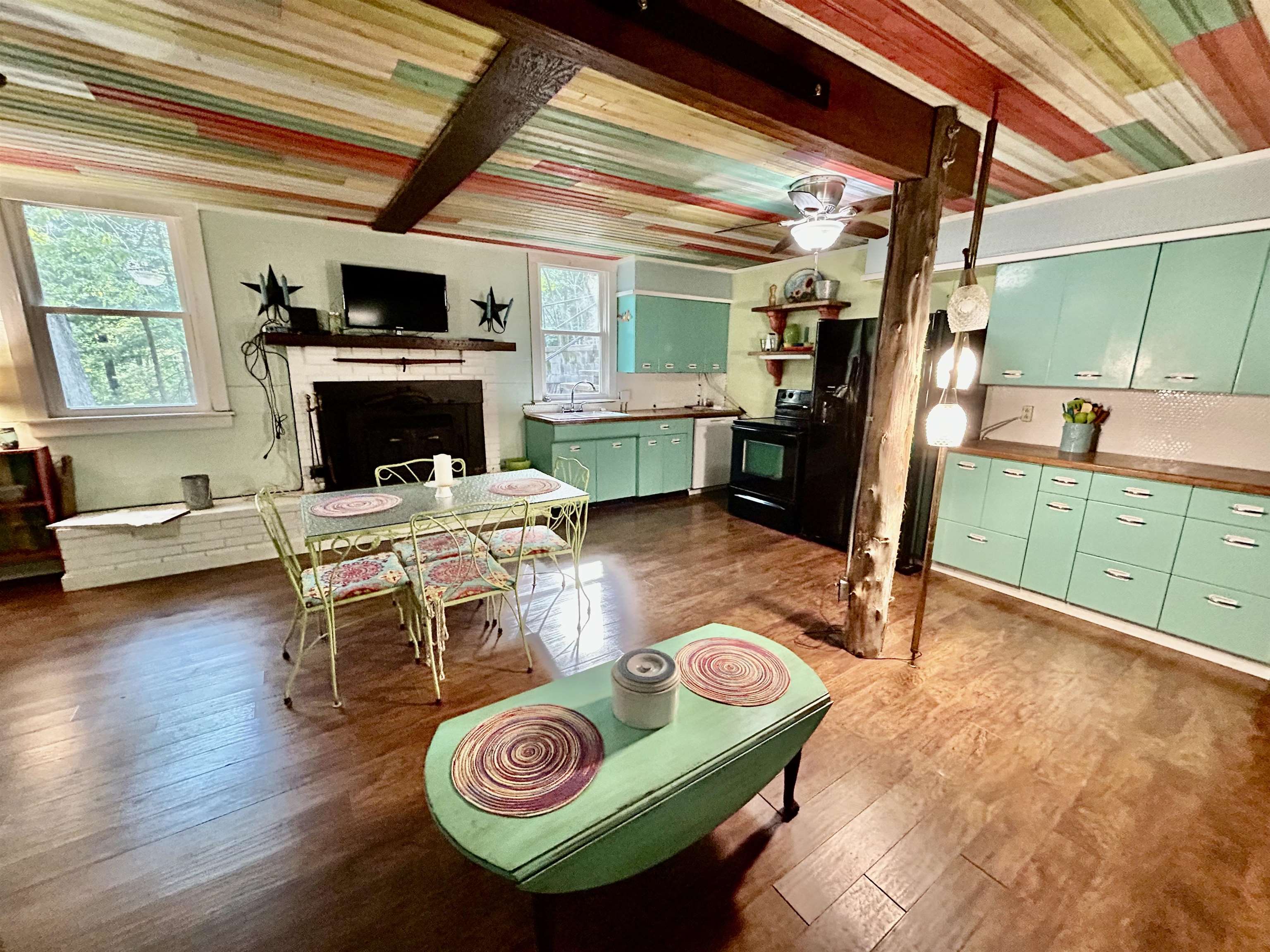 460 Port Lane Counce, TN 38326 - Photo 5 of 23 Dining room with dark wood finished floors, beam ceiling, and a fireplace