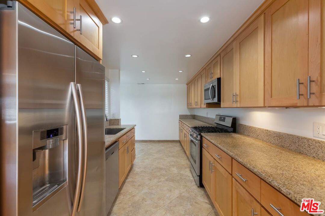 27 Buccaneer Street Marina del Rey, CA 90292 - Photo 5 of 15 a kitchen with stainless steel appliances granite countertop a refrigerator a sink and a stove