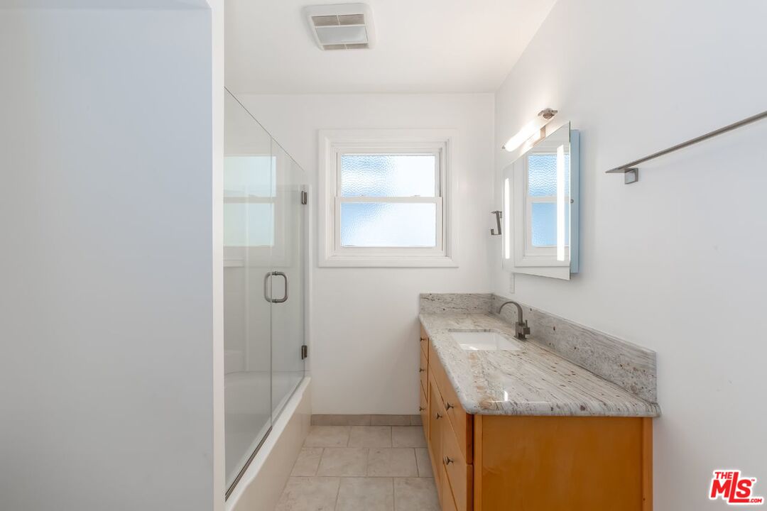 27 Buccaneer Street Marina del Rey, CA 90292 - Photo 9 of 15 a bathroom with a granite countertop sink and a mirror