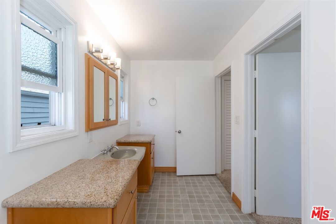 27 Buccaneer Street Marina del Rey, CA 90292 - Photo 10 of 15 a bathroom with a granite countertop sink and a mirror