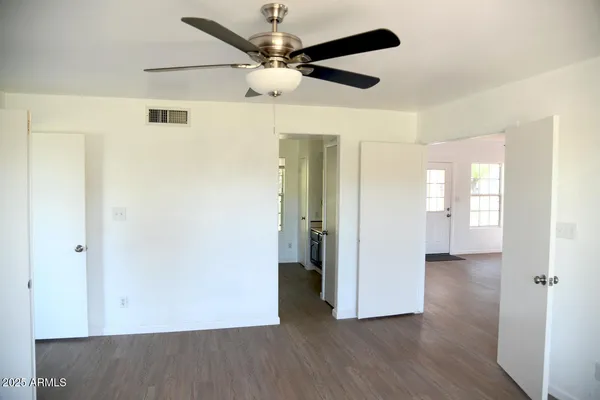 a view of an empty room with wooden floor