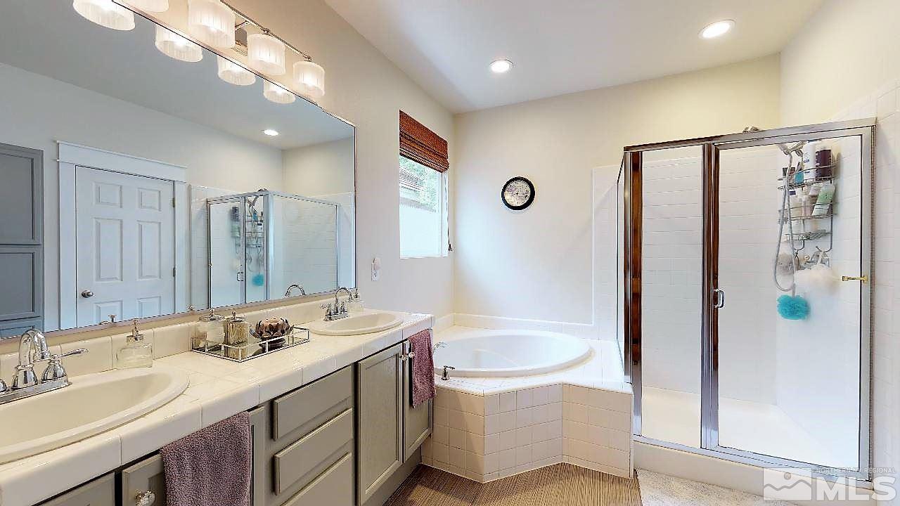10290 Wolf Ridge Way Reno, NV 89521 - Photo 18 of 22 a bathroom with a granite countertop sink a toilet a large mirror and shower