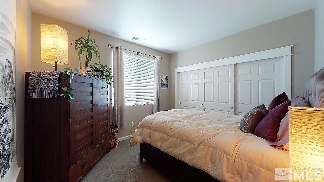 10290 Wolf Ridge Way Reno, NV 89521 - Photo 20 of 22 a bedroom with a bed dresser and a large mirror