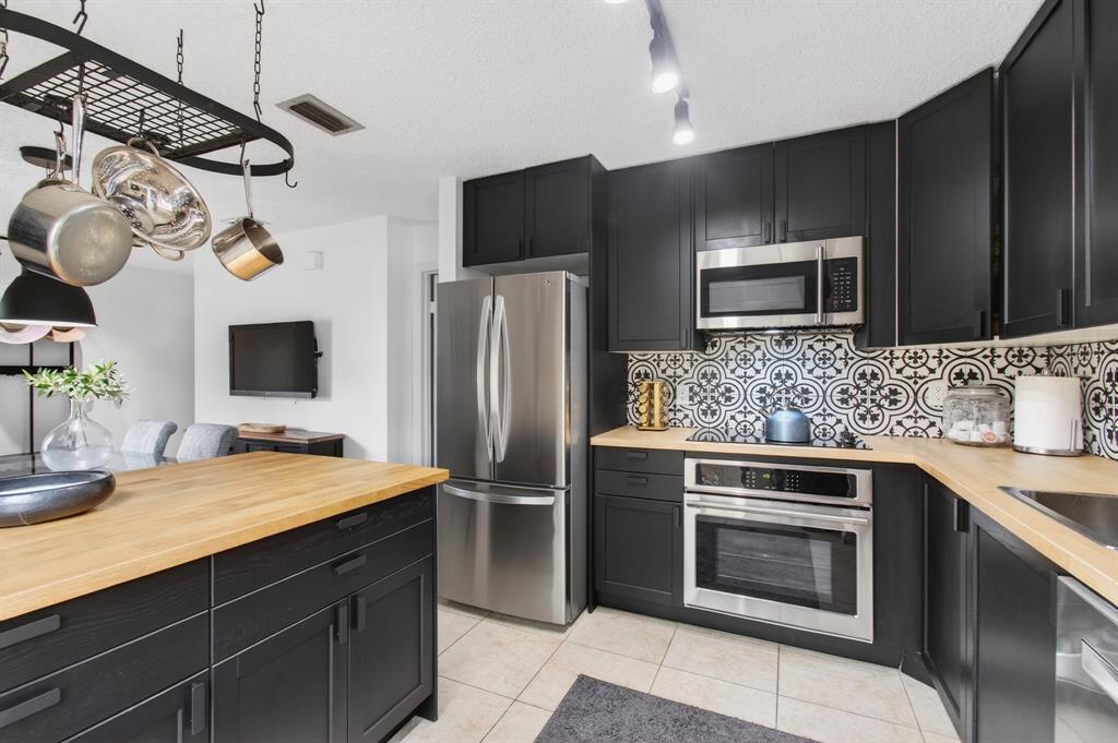 6621 Via Regina, Unit 6621 Boca Raton, FL 33433 - Photo 6 of 100 a kitchen with stainless steel appliances a stove a microwave and refrigerator
