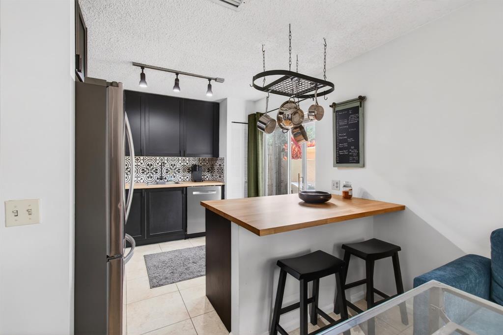 6621 Via Regina, Unit 6621 Boca Raton, FL 33433 - Photo 10 of 100 a kitchen with stainless steel appliances kitchen island a table and chairs in it