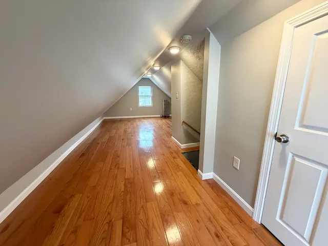 a view of a livingroom with wooden floor and staircase