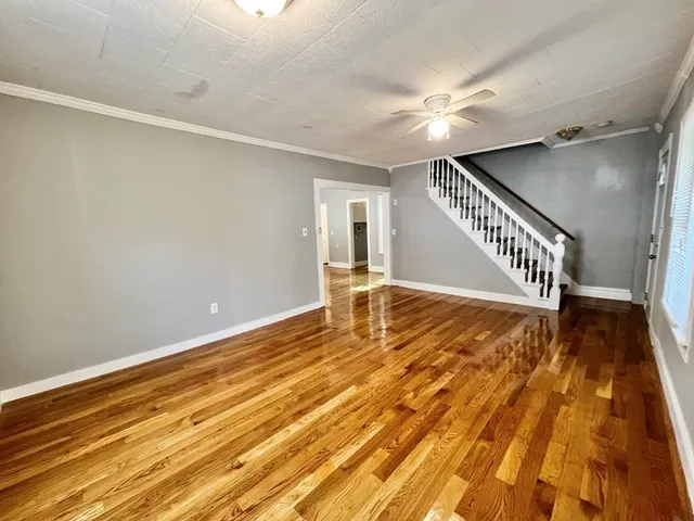 a view of an empty room with wooden floor