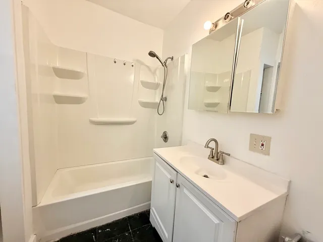 a bathroom with a tub sink and mirror