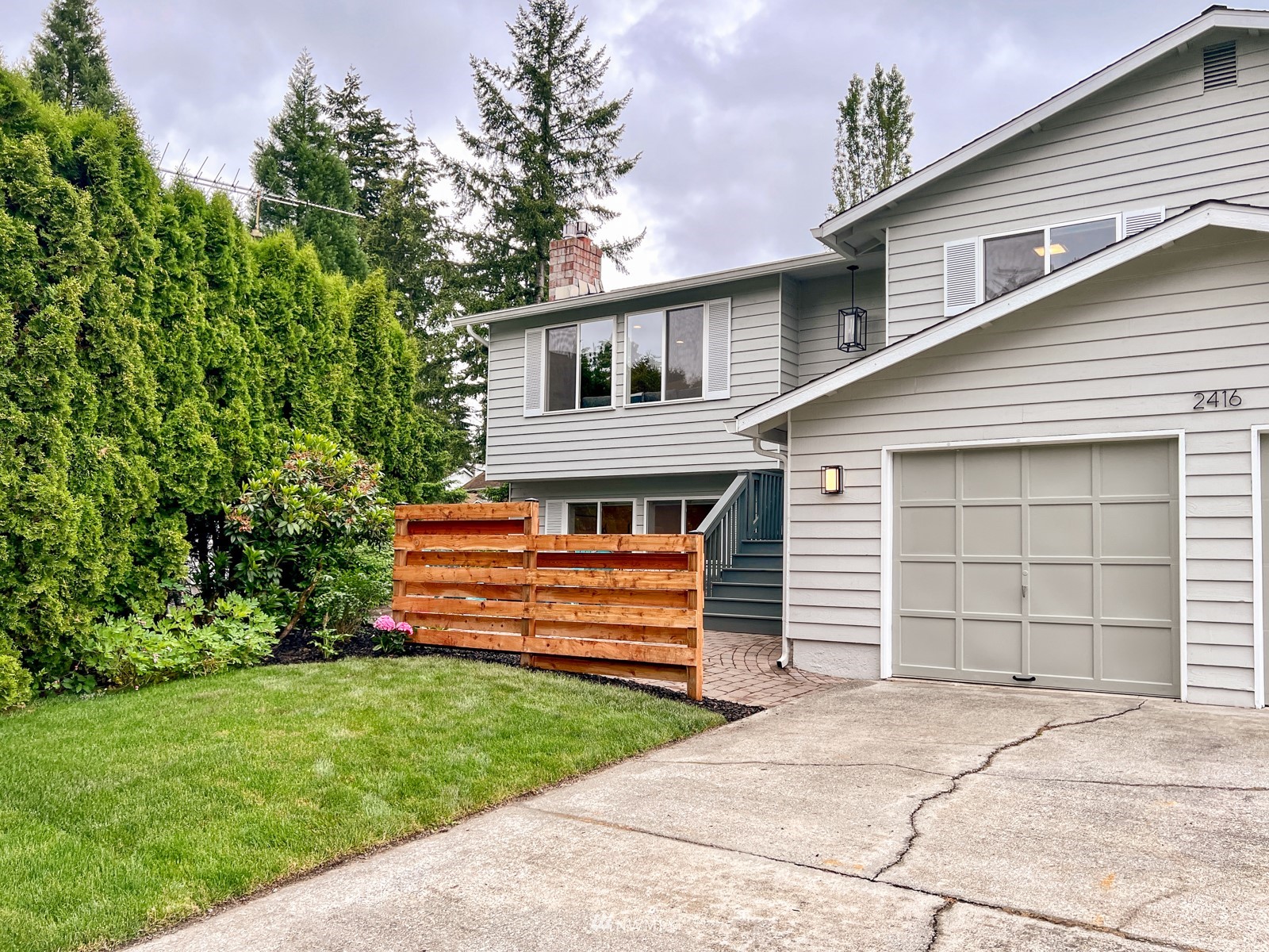 2416 165th Place Southeast Bothell, WA 98012 - Photo 3 of 39 a front view of a house with a garden