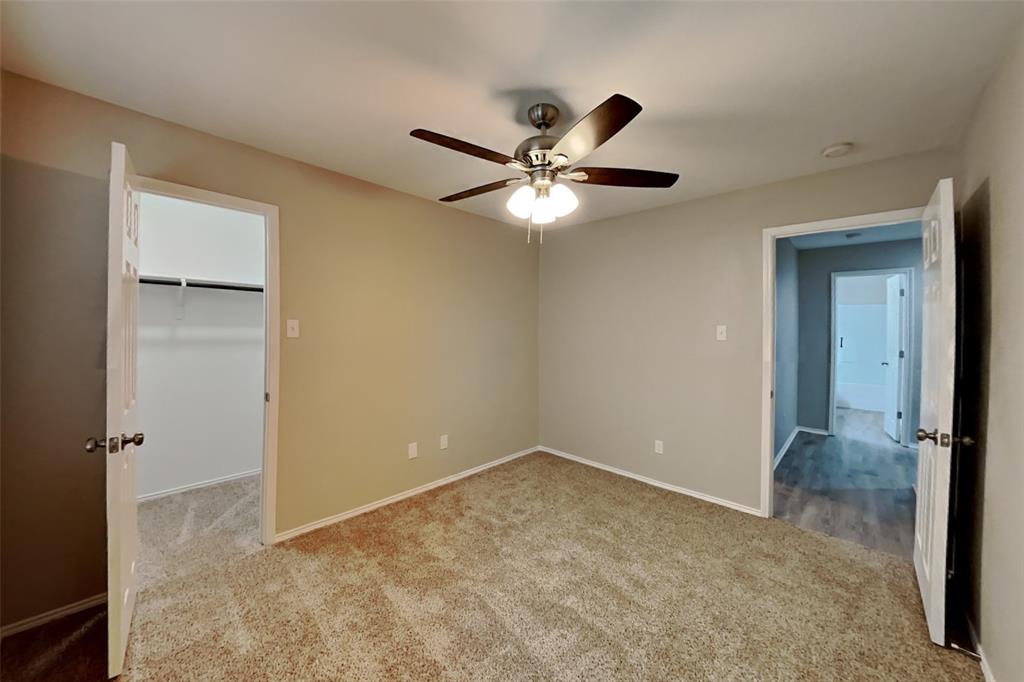4204 Highgate Road Fort Worth, TX 76244 - Photo 11 of 19 Unfurnished bedroom with a walk in closet, light colored carpet, and a ceiling fan