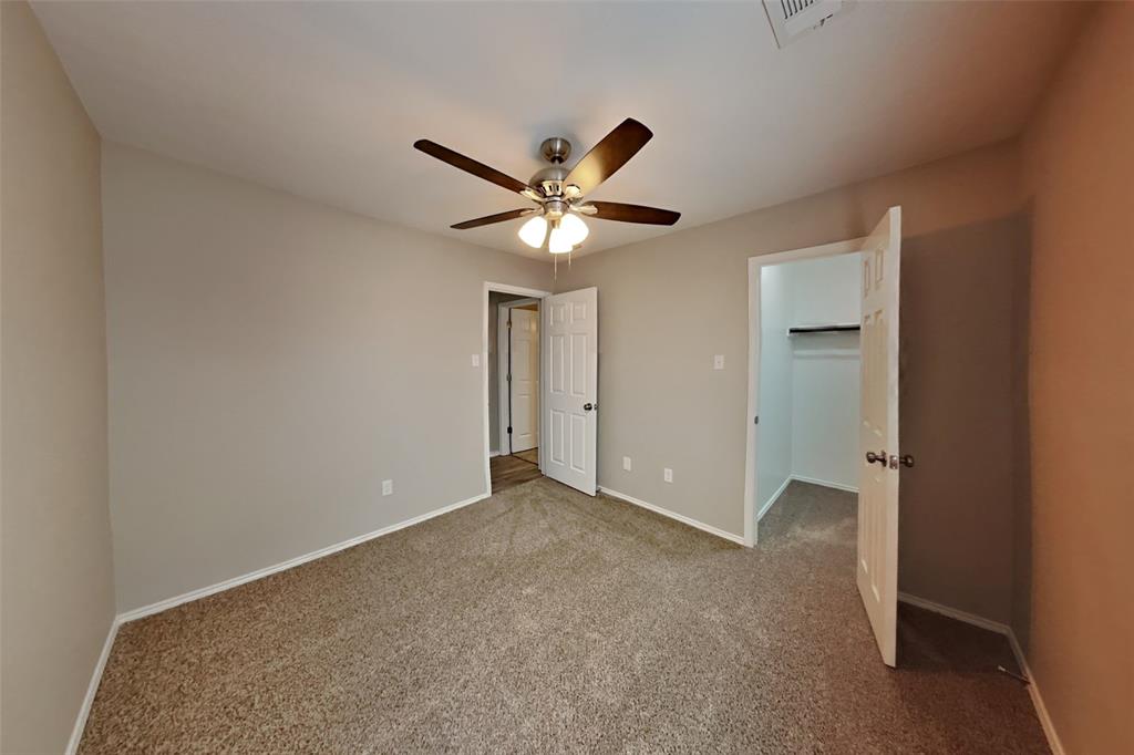 4204 Highgate Road Fort Worth, TX 76244 - Photo 15 of 19 Unfurnished bedroom featuring a walk in closet, carpet floors, and a ceiling fan