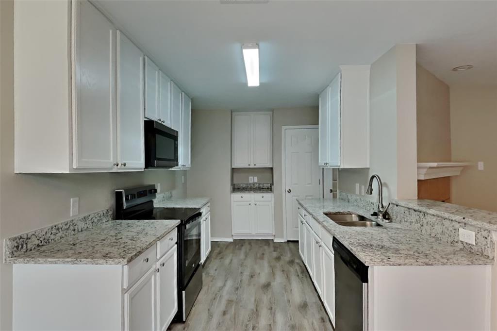 4204 Highgate Road Fort Worth, TX 76244 - Photo 5 of 19 Kitchen with appliances with stainless steel finishes, light stone countertops, light wood-style flooring, and white cabinets