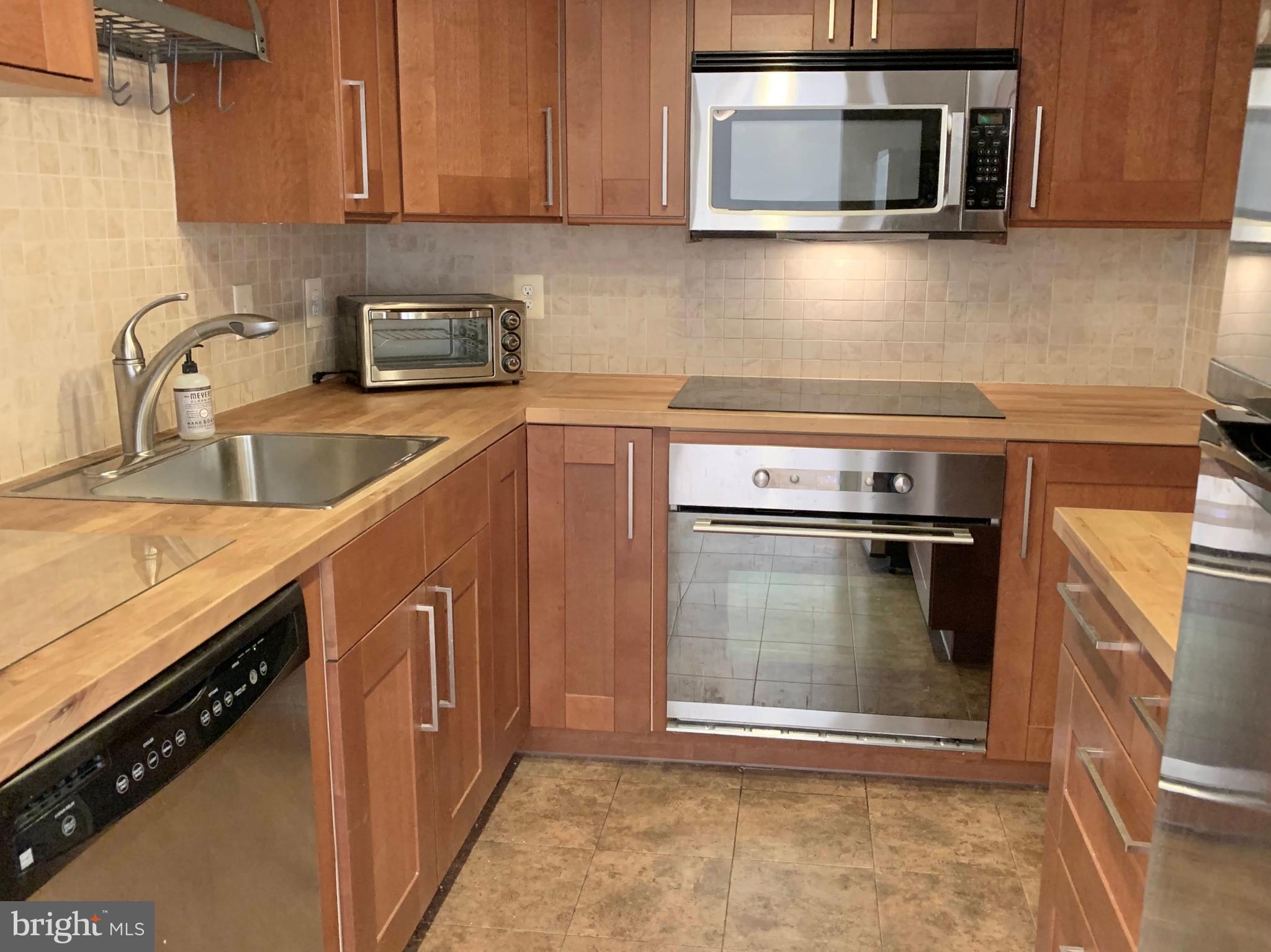 560 N Street Southwest, Unit N304 Washington, DC 20024 - Photo 3 of 22 a kitchen with stainless steel appliances granite countertop a stove microwave and sink
