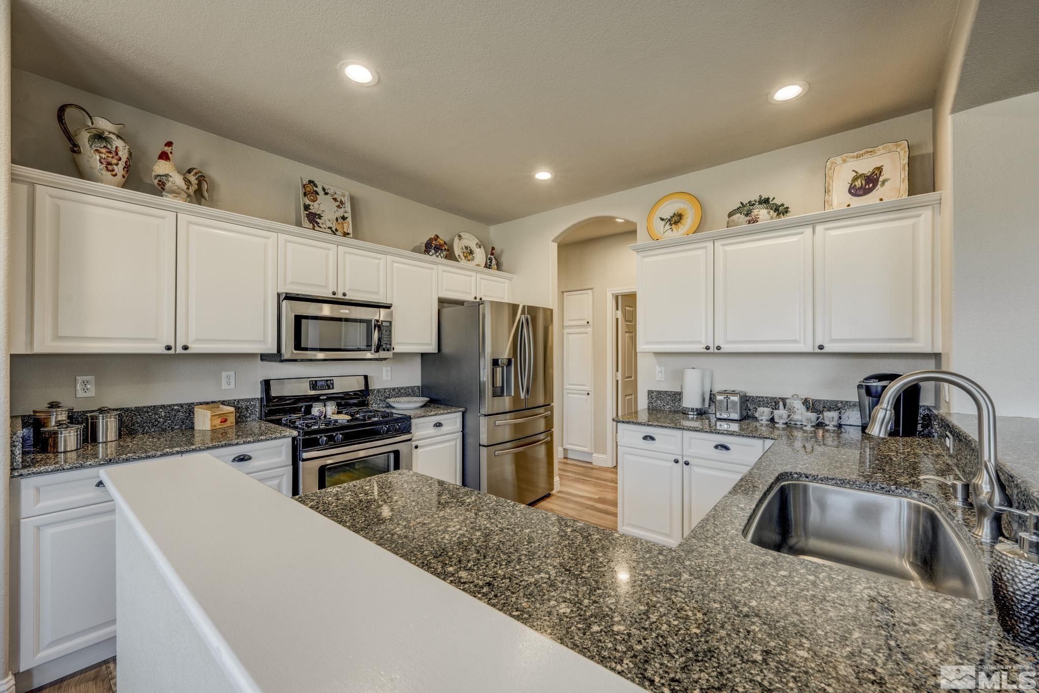 1825 D'Arques Court Reno, NV 89521 - Photo 13 of 40 a kitchen with granite countertop a sink stainless steel appliances and cabinets