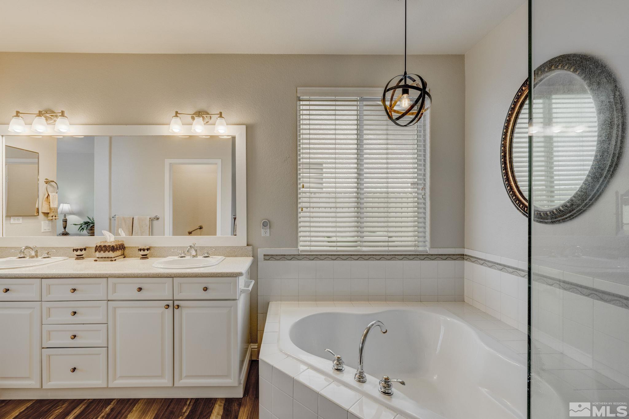 1825 D'Arques Court Reno, NV 89521 - Photo 23 of 40 a bathroom with a bathtub a sink and a mirror