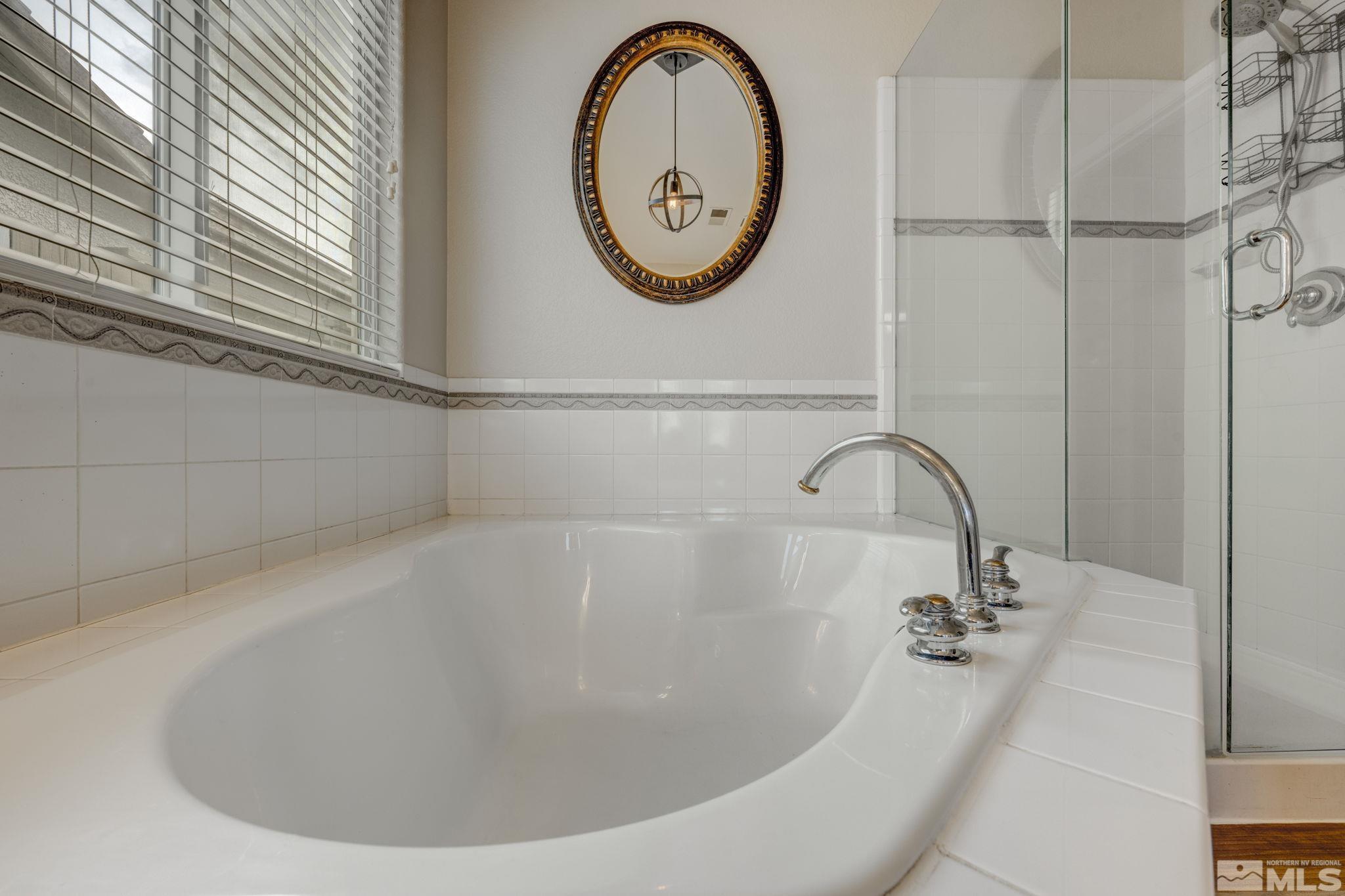 1825 D'Arques Court Reno, NV 89521 - Photo 24 of 40 a bathroom with a bathtub and a window