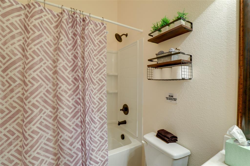 4502 Ridgeway Drive Mansfield, TX 76063 - Photo 18 of 29 a bathroom with a shower curtain and a toilet