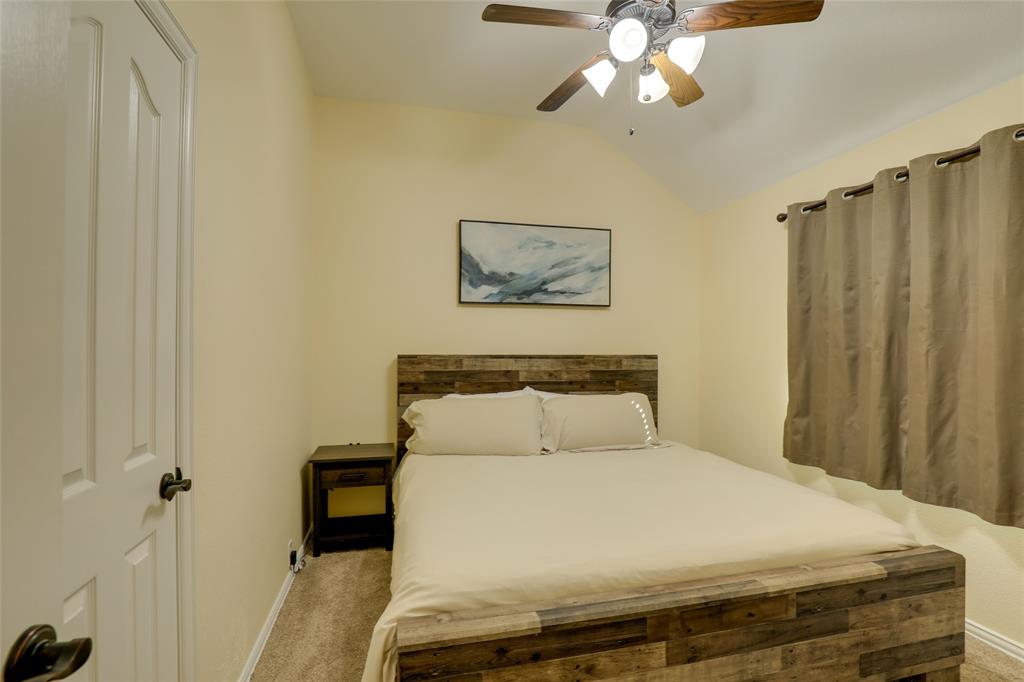 4502 Ridgeway Drive Mansfield, TX 76063 - Photo 20 of 29 a bedroom with a bed and a chandelier