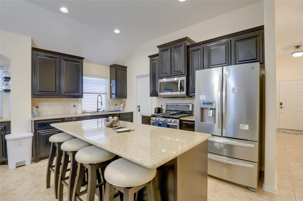 4502 Ridgeway Drive Mansfield, TX 76063 - Photo 5 of 29 a kitchen with stainless steel appliances a table chairs refrigerator and cabinets