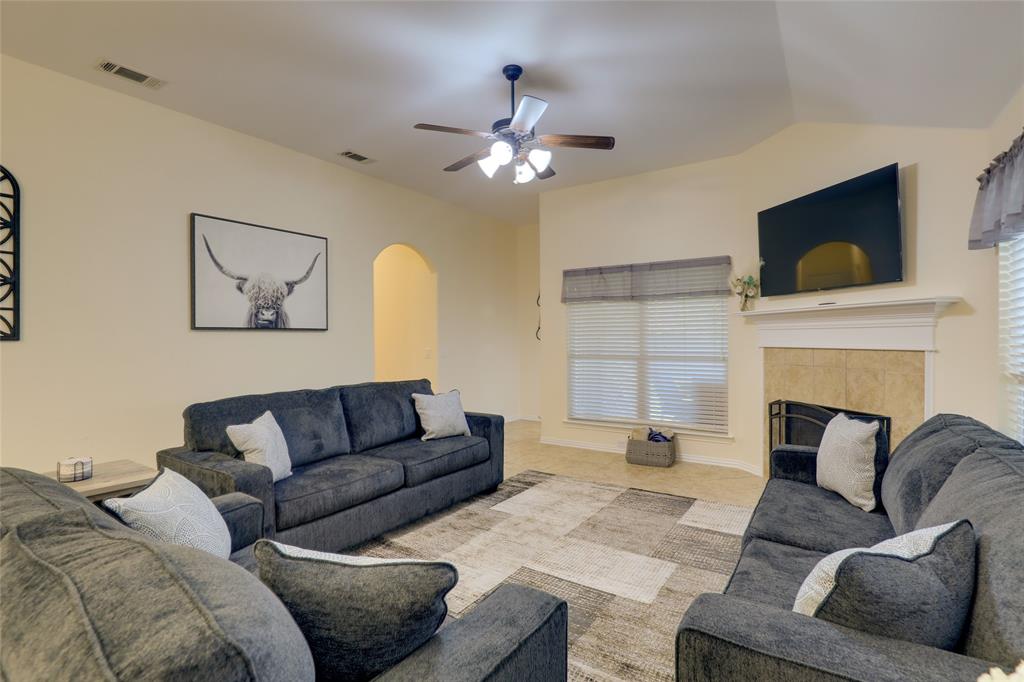 4502 Ridgeway Drive Mansfield, TX 76063 - Photo 6 of 29 a living room with furniture a flat screen tv and a fireplace