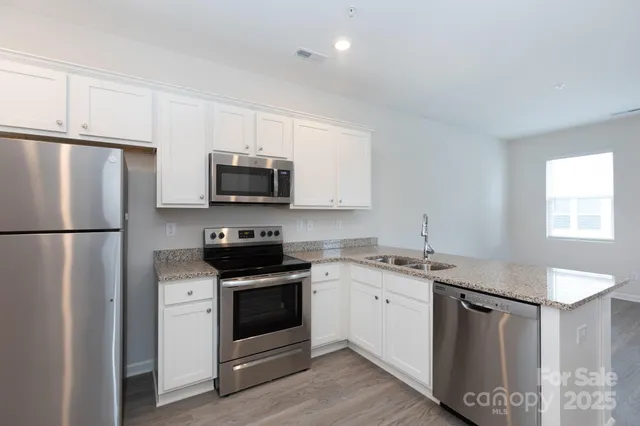 a kitchen with stainless steel appliances granite countertop a stove a refrigerator and a microwave