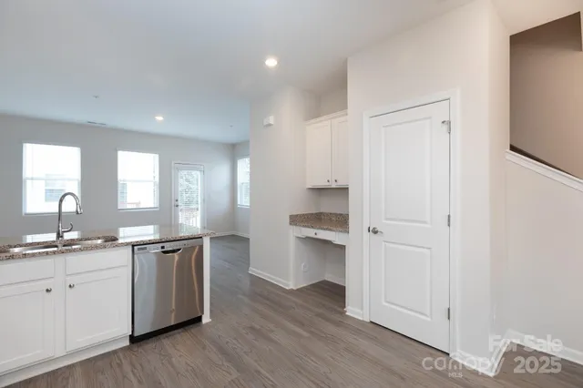 a kitchen with a sink cabinets and wooden floor