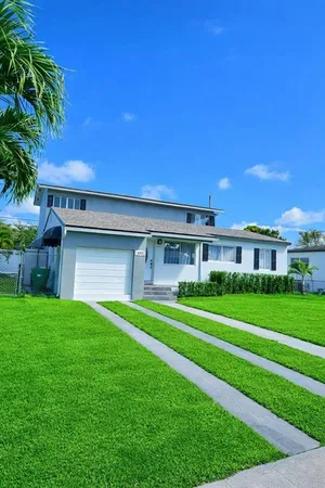a front view of a house with a yard and trees