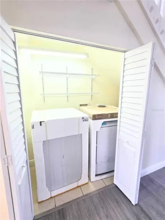 a utility room with a window dryer and hardwood