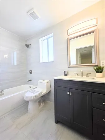 a bathroom with a double vanity sink mirror and toilet