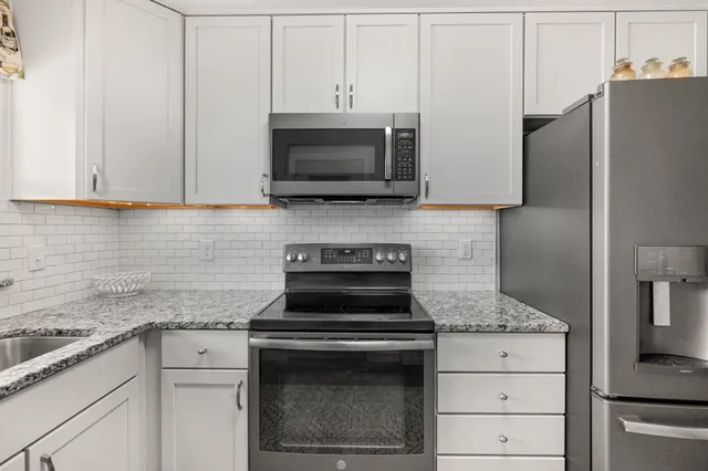a kitchen with cabinets stainless steel appliances and a counter space