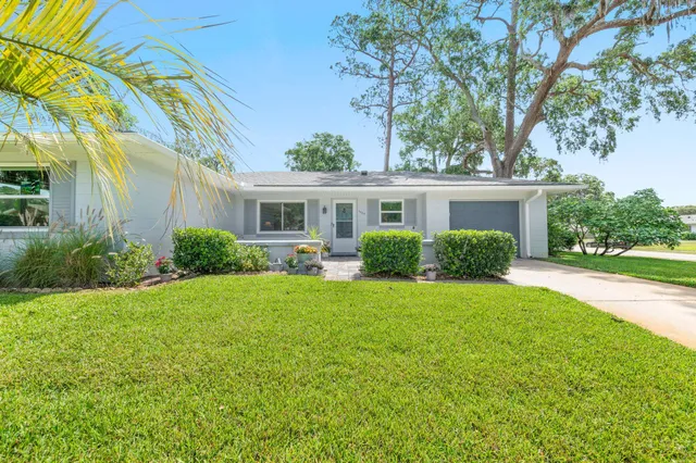 a front view of a house with porch and garden