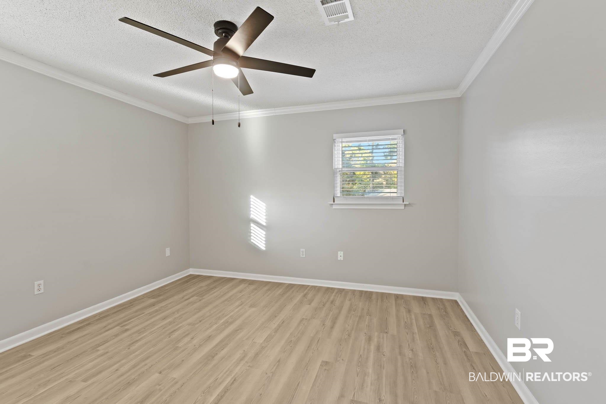 608 Southern Way Daphne, AL 36527 - Photo 22 of 35 Unfurnished room with light wood-type flooring, crown molding, a textured ceiling, and ceiling fan