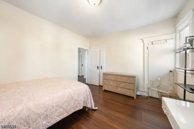 a bedroom with a bed and a wooden floor