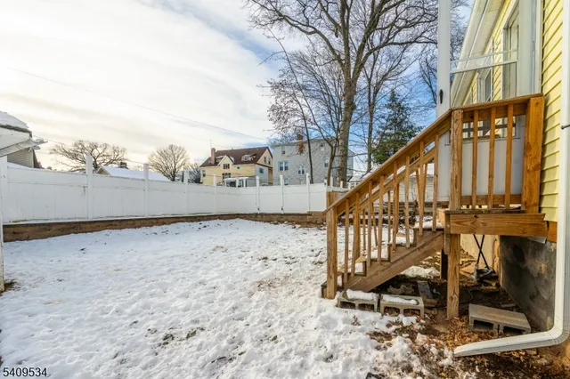 a view of staircase with wooden fence and a bench
