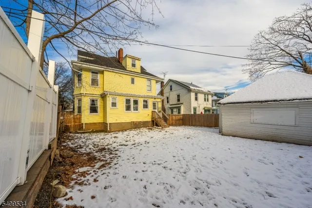 a view of a blue house with a yard