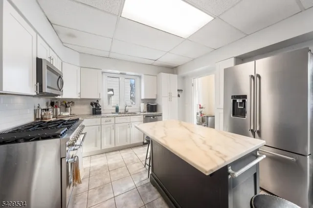 a large kitchen with a stove a refrigerator and a sink