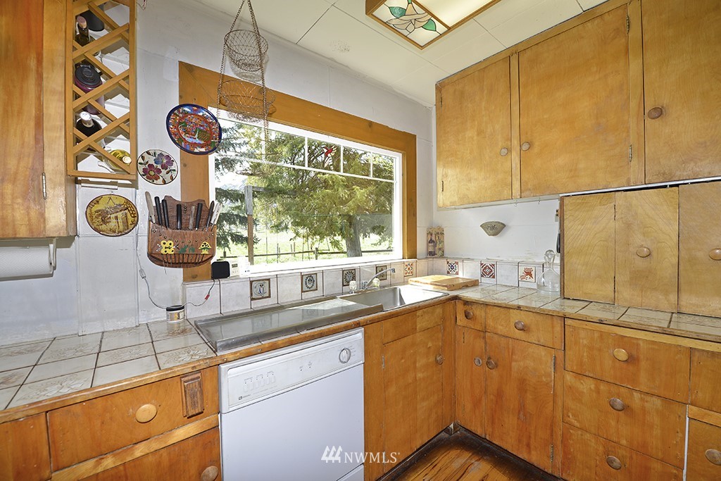 322 North End Omak Lake Road Omak, WA 98841 - Photo 29 of 40 a kitchen with stainless steel appliances a sink and a window