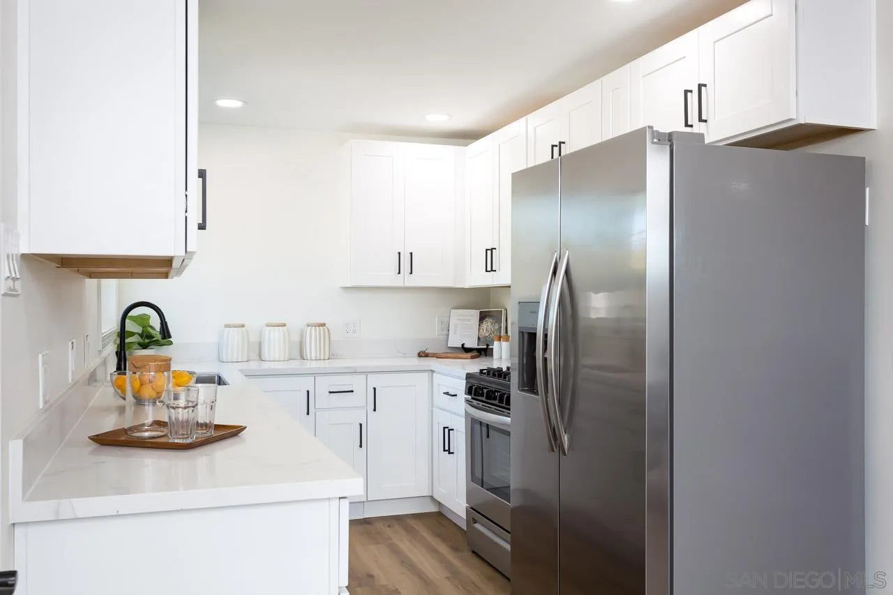 9111 Rosedale Drive Spring Valley, CA 91977 - Photo 8 of 32 a kitchen with stainless steel appliances a refrigerator sink and cabinets